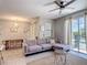 Open floor plan with a comfortable gray sofa and view to dining and pool area at 850 Pebble Beach Dr, Davenport, FL 33896