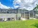Outdoor oasis showcasing a screened pool, patio, AC units, and lush green grass, perfect for relaxation and outdoor enjoyment at 850 Pebble Beach Dr, Davenport, FL 33896
