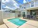 Relaxing backyard pool area featuring a screened enclosure, stone patio and safety fence at 850 Pebble Beach Dr, Davenport, FL 33896
