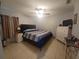 Comfortable bedroom featuring tile floors, a ceiling fan, and ample natural light, creating a relaxing atmosphere at 8509 Sw 136Th Loop, Ocala, FL 34473
