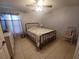 Inviting bedroom with neutral tones, tile flooring, ceiling fan, and a cozy spot for reading at 8509 Sw 136Th Loop, Ocala, FL 34473