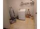Functional laundry area with a washing machine, dryer, storage shelves, and tile flooring at 8509 Sw 136Th Loop, Ocala, FL 34473