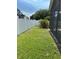 Green backyard with a vinyl fence and patio screen enclosure at 9003 Pecky Cypress Way, Orlando, FL 32836