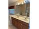 Bathroom with double sink vanity, large mirror, and walk-in shower at 9003 Pecky Cypress Way, Orlando, FL 32836
