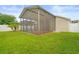 Exterior view of screened lanai and lush green lawn at 9003 Pecky Cypress Way, Orlando, FL 32836