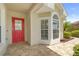 Inviting front entrance with a red door and a charming bay window feature at 9003 Pecky Cypress Way, Orlando, FL 32836