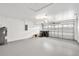 Spacious garage featuring neutral paint, overhead lighting and epoxy flooring at 9003 Pecky Cypress Way, Orlando, FL 32836
