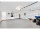 Spacious garage featuring neutral paint, overhead lighting and epoxy flooring at 9003 Pecky Cypress Way, Orlando, FL 32836
