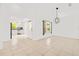 Bright living space featuring neutral tile flooring, modern lighting, and access to the kitchen at 9003 Pecky Cypress Way, Orlando, FL 32836