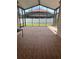 Enclosed patio with tiled floor offers a serene view of the backyard and pool area at 9003 Pecky Cypress Way, Orlando, FL 32836