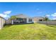 Well-kept backyard with a grassy lawn, privacy fence, and views of the screened patio area, perfect for outdoor enjoyment at 913 Sabal Breeze Ln, Apopka, FL 32703