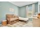 Bedroom with blue walls, and a wooden crib next to a window at 913 Sabal Breeze Ln, Apopka, FL 32703