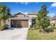 Inviting one-story home featuring a well-kept lawn, a spacious driveway, and a two-car garage at 913 Sabal Breeze Ln, Apopka, FL 32703