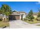 Well-maintained single-story home with a lush green lawn, a two-car garage, and manicured landscaping at 913 Sabal Breeze Ln, Apopka, FL 32703