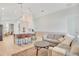Bright living room featuring hardwood floors, an island with bar seating, and a comfortable gray sofa at 913 Sabal Breeze Ln, Apopka, FL 32703