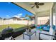 Relaxing screened patio with a grill, comfortable seating, and view of the backyard, perfect for outdoor gatherings at 913 Sabal Breeze Ln, Apopka, FL 32703