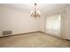 Bright dining room featuring carpet flooring, a chandelier, and large windows at 9206 Everwood St, Orlando, FL 32825