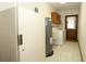 Inside laundry room with tile flooring, washer and dryer, water heater, and access to the backyard at 9206 Everwood St, Orlando, FL 32825