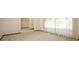 Bright living room featuring neutral carpet and large windows with sheer curtains at 9206 Everwood St, Orlando, FL 32825