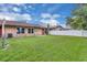 Spacious backyard showcasing a lush green lawn, mature landscaping and a white privacy fence at 978 Calanda Ave, Orlando, FL 32807