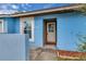 Close-up of front entrance of a light blue home featuring a well-lit doorway and a small front porch at 978 Calanda Ave, Orlando, FL 32807