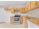 Traditional kitchen featuring wood cabinetry, stainless steel range, and ceramic tile flooring at 978 Calanda Ave, Orlando, FL 32807