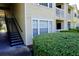 Exterior side view of a condo building with stairs leading to upper units and well-maintained landscaping at 1031 S Hiawassee Rd # 2514, Orlando, FL 32835