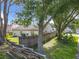 A fenced backyard features mature trees providing shade and a view of the home's exterior at 1044 Dees Dr, Oviedo, FL 32765
