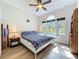This sunny bedroom features hardwood floors, ceiling fan, and bright natural light from the windows at 1044 Dees Dr, Oviedo, FL 32765