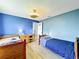 Comfortable bedroom painted with bright blue color features two beds and wood floor at 1044 Dees Dr, Oviedo, FL 32765