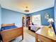 This bedroom with blue walls has wood flooring, ceiling fan and a window for natural light at 1044 Dees Dr, Oviedo, FL 32765