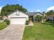 A well-maintained single-story home featuring a brick driveway and lush green lawn at 1044 Dees Dr, Oviedo, FL 32765