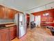 Open kitchen showcasing stainless steel refrigerator, tile floor, wood cabinets and red accent wall at 1044 Dees Dr, Oviedo, FL 32765