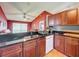Kitchen featuring dark wood cabinets, tile floors, granite countertops and stainless steel sink at 1044 Dees Dr, Oviedo, FL 32765