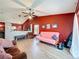 Open-concept living space with light wood floors, red accent wall, and kitchen access at 1044 Dees Dr, Oviedo, FL 32765