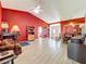 Spacious living room with red accent walls, light wood floors, and an open layout to the dining area at 1044 Dees Dr, Oviedo, FL 32765