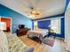 Bright primary bedroom featuring wood floors, vaulted ceiling, blue walls, ceiling fan and natural light at 1044 Dees Dr, Oviedo, FL 32765