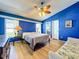 Comfortable primary bedroom showcasing vaulted ceiling, blue accent wall, wood floors and ceiling fan at 1044 Dees Dr, Oviedo, FL 32765