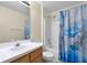 Neutral bathroom with tub/shower combo and a modern blue and gold shower curtain at 1113 Canopy Oaks Dr, Minneola, FL 34715