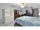Bedroom with neutral walls, ceiling fan, grey upholstered bed with patterned blue and white quilt at 1113 Canopy Oaks Dr, Minneola, FL 34715