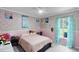 A bedroom with floral wallpaper, a bed with pink sheets, and light blue curtains on the window at 1113 Canopy Oaks Dr, Minneola, FL 34715