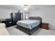 Bedroom featuring neutral walls, ceiling fan, and grey upholstered bed with patterned blue and white quilt at 1113 Canopy Oaks Dr, Minneola, FL 34715