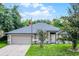 Charming single-story home with a well-manicured lawn and an attached two-car garage at 1113 Canopy Oaks Dr, Minneola, FL 34715