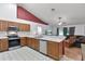 Open kitchen with stainless steel appliances, oak cabinets, and a breakfast bar overlooking the living area at 1113 Canopy Oaks Dr, Minneola, FL 34715