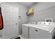 Laundry room with gray walls, a Maytag washer and dryer, wire shelving, and a closed door at 1113 Canopy Oaks Dr, Minneola, FL 34715