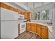 Bright kitchen featuring oak cabinets, white appliances and wood grain flooring at 1310 Oregon St, Orlando, FL 32803