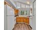 Functional kitchen featuring wood cabinets, white appliances, and plenty of natural light at 1310 Oregon St, Orlando, FL 32803