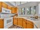 Bright kitchen featuring oak cabinets, white appliances and wood grain flooring at 1310 Oregon St, Orlando, FL 32803