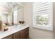 Elegant bathroom with vanity, decorative light fixture, and window with plantation shutters at 1341 Place Picardy, Winter Park, FL 32789
