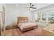 Bright bedroom boasts a beautiful wood bed frame, large windows, and a ceiling fan at 1341 Place Picardy, Winter Park, FL 32789